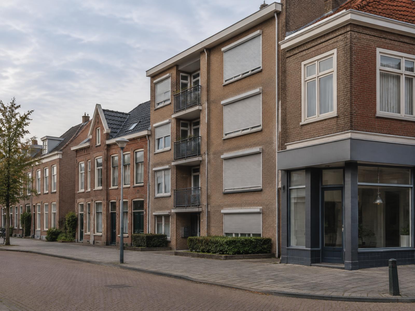 Nederlandse straat met gevarieerde panden: woonhuis, appartementencomplex en winkelruimte